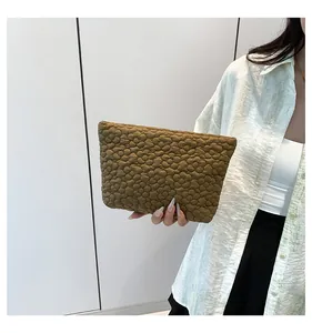 Close-up of olive green quilted handbag with bubble flower texture and soft puffy design