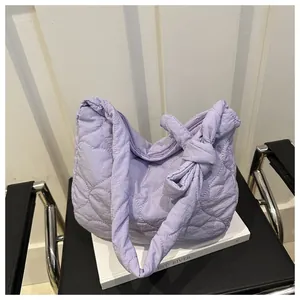 Detail of lavender quilted tote bag with heart patterns and oversized shoulder bow