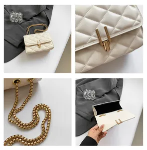 Detail of cream quilted crossbody bag featuring gold metal chain strap and lock closure