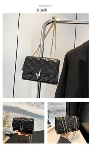 Detail of black quilted leather shoulder bag featuring gold U-shaped metal buckle and chain