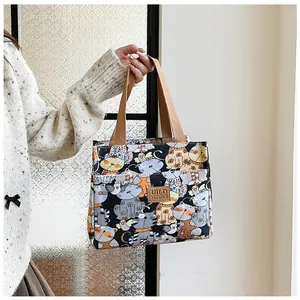 Bolsa de lona para el almuerzo con estampados de gatos llevada por una modelo