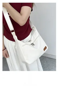 Detailed view of white waterproof crossbody dumpling bag with adjustable shoulder strap