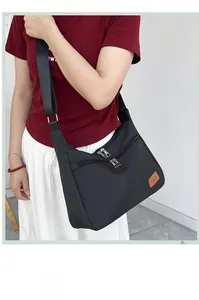Detail view of black waterproof nylon crossbody bag featuring dual front zipper pockets