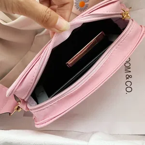 Detail of pink PU leather crossbody bag interior with phone and lipstick inside