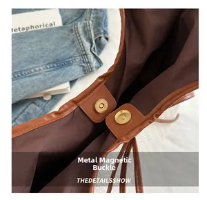 Detail view of the magnetic closure on a woven tote bag with brown PU leather trim