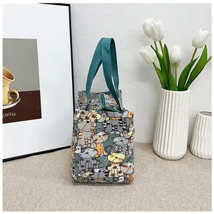 Detalle de una bolsa de lona verde para el almuerzo con gatos y cremallera superior