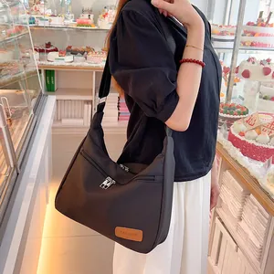 Large black nylon crescent bag with adjustable strap and multiple silver zippers