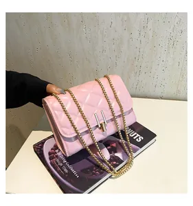 Detailed view of pink quilted handbag with gold chain strap and metallic twist lock closure