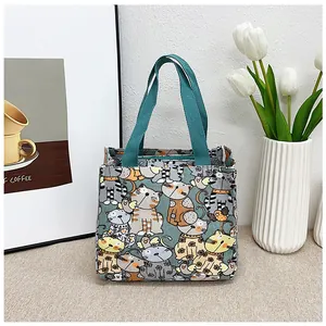 Detalle de bolsa de lona para almuerzo con estampados de gatos y asas verdes fuertes