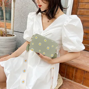 Chic light green crossbody bag with white daisy prints and matching wide shoulder strap