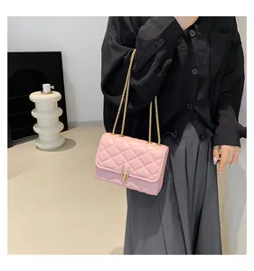 Detail of pink quilted crossbody bag with gold chain strap and metallic clasp closure