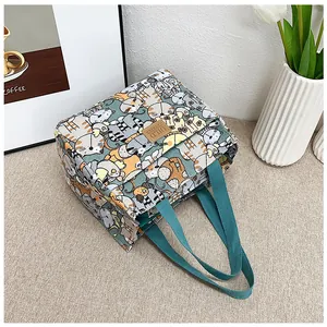 Detalle de bolsa de lona para almuerzo con estampado de gato y logo de cuero