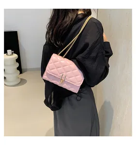Detail of pink quilted diamond pattern chain bag showing gold metal clasp and leather texture