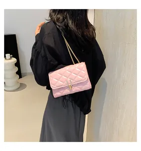 Pink quilted crossbody bag with gold chain strap worn by a model on the shoulder
