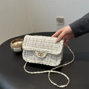 Elegante bolso bandolera de tweed blanco con cadena dorada y cierre giratorio de metal