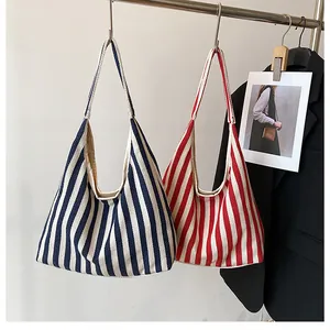 Détail de cabas en toile à rayures bleu marine et rouges avec larges bandoulières