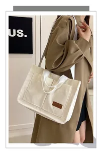 Detail of white corduroy tote bag with dual front pockets and durable webbing handles