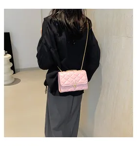 Detail of pink quilted leather shoulder bag with gold chain strap and U-shaped metal lock