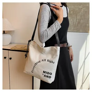 Dettaglio della borsa tote in tela con manici in pelle nera e nodi decorativi laterali