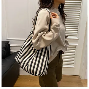Vue détaillée du grand sac à bandoulière en toile à rayures noires et blanches porté