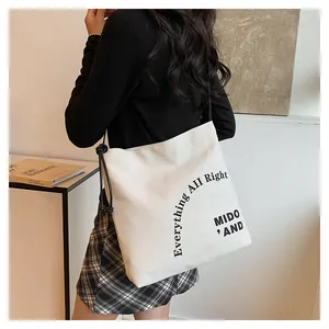 Dettaglio della borsa tote in tela bianca con coulisse nera e scritte stile minimalista
