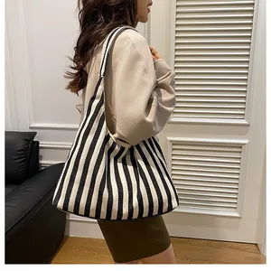 Vue latérale détaillée du grand sac cabas en toile à rayures noires et blanches porté