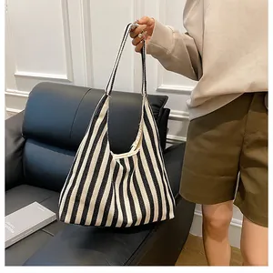 Détail de la texture d'un grand sac cabas en toile à rayures noires et blanches chic