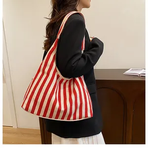 Détail du sac cabas en toile à rayures rouges et blanches avec une grande capacité et texture