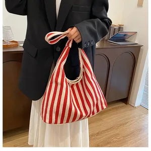 Gros plan du sac cabas en toile à rayures rouges et blanches au design hobo