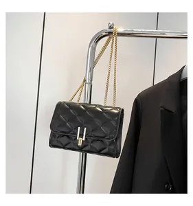 Close-up of black quilted chain bag with gold metal lock and elegant diamond stitching