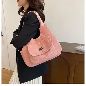 Close-up of pink corduroy tote bag with QIANNING label shown on model side shoulder