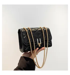 Close-up of quilted black leather bag with a unique gold and silver metallic lock detail