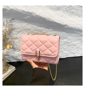Close-up of pink quilted crossbody bag with gold chain strap and metal lock closure
