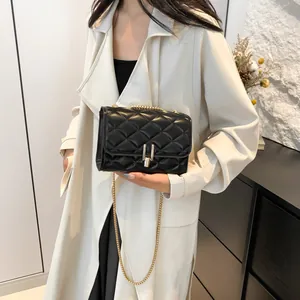 Classic black quilted chain bag with gold metal buckle shown on a model in trench coat