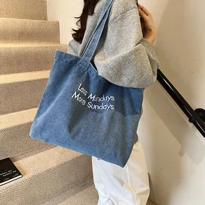 Blue denim tote bag with 'Less Mondays More Sundays' embroidery for casual daily use
