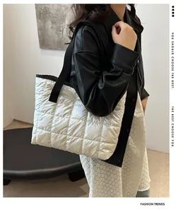 Vue détaillée du sac cabas argenté matelassé avec tissu brillant et bandoulière noire