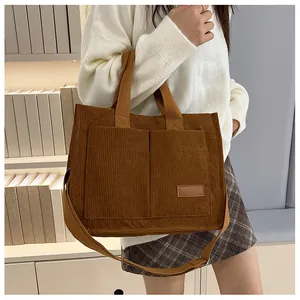 Detail of brown corduroy tote bag featuring front pockets and adjustable strap for women