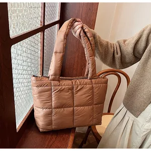 Dettaglio della borsa tote trapuntata color caramello con manici imbottiti e chiusura a zip