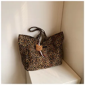 Nahaufnahme der Canvas-Einkaufstasche mit Leopardenmuster und Bärenanhänger