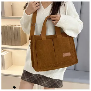 Detail of caramel corduroy tote bag showing front pockets and leather fashion label