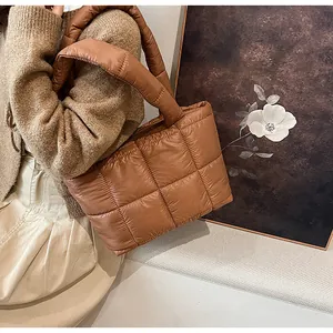 Dettaglio di una borsa tote imbottita marrone con trama trapuntata e manici morbidi