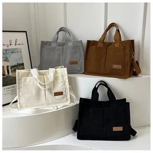 Detail of corduroy tote bags in four colors with fashion label and adjustable straps