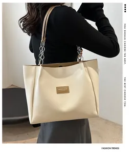 Detail of cream leather tote bag with silver chain strap and stylish side profile