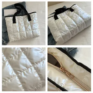 Gros plan détaillé sur la texture matelassée blanche du cabas et le zip doré brillant
