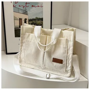 Detail view of cream corduroy tote bag with dual straps and fashion leather patch