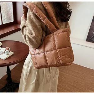 Dettaglio di una borsa tote in piumino trapuntato marrone con manici imbottiti