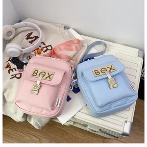 Detail of pink and blue mini crossbody bags with cute bear charms on a white suitcase