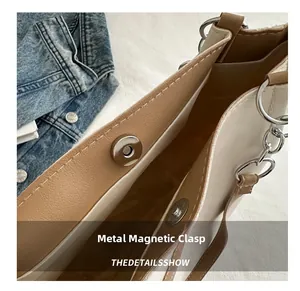 Detail shot of the magnetic hardware snap closure on a high-quality leather tote bag