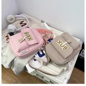 Detail of pink and beige mini crossbody bags with cute bear charm and adjustable straps