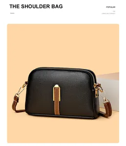 Close-up of black litchi pattern shell bag with brown leather strip and gold U-buckle